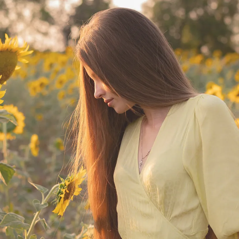 femme-relax-4 Image d'une femme vue de profil relaxée se promenant dans un champ de tournesols