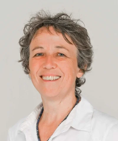 Portrait de Anne DELMAS souriante et qui porte une chemise blanche