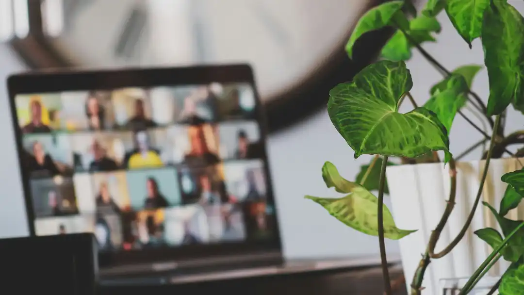 Ecran posé sur une table montrant les vignettes des participants à une vidéo conférence